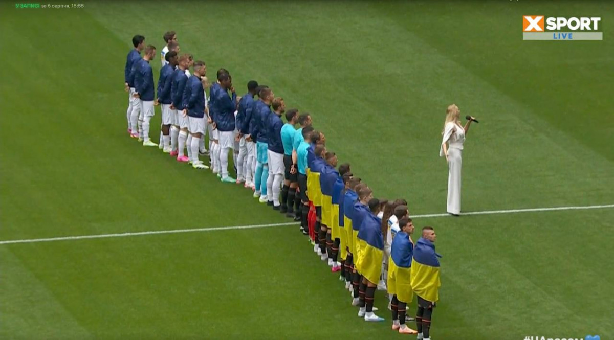Оля Полякова исполняет гимн Украины на футбольном матче в Лондоне.